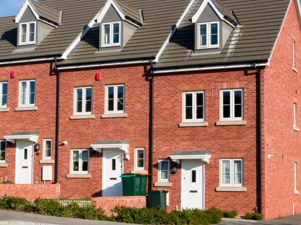 Watsons & Housing Associations new build snagging survey picture of a terrace of red brick properties road side on a clear sunny day